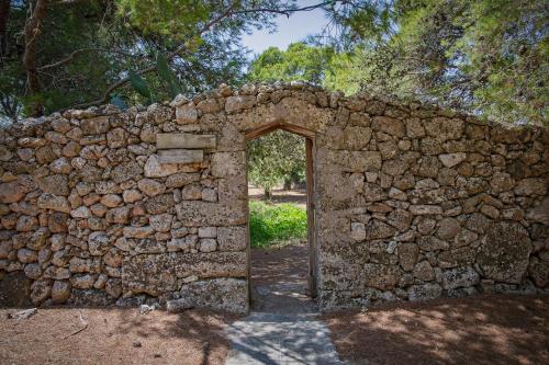 an old stone wall with an open door at torre casciani in Ugento