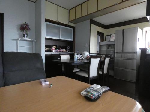 eine Küche und ein Esszimmer mit einem Tisch mit zwei Fernbedienung in der Unterkunft Minpaku Suzuki in Hiraizumi