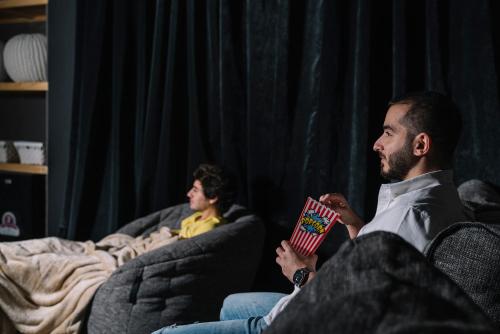 two men sitting on couch reading a book at Dara Al Yammamah Hotel - Formerly Nuzl Shada in Jeddah
