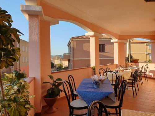 un patio con mesas y sillas en el balcón en Riccio Hotel, en La Maddalena