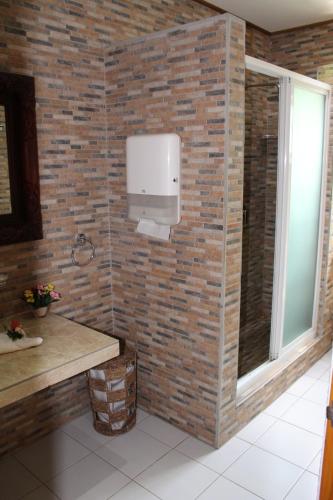 a bathroom with a brick wall with a paper towel dispenser at Farida Apartments in Pointe Au Sel 