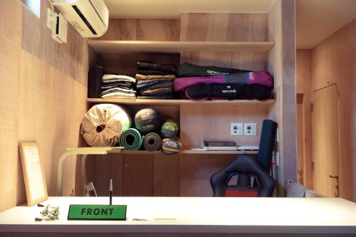 a room with a shelf with items on it at BEACH AND FIELD INN in Sapporo