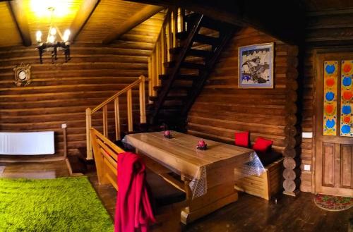 a wooden room with a wooden table and stairs at Шаленарозі in Migovo