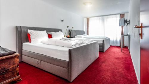 a bedroom with two beds and a red carpet at Hotel am Museum Köln in Cologne