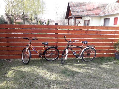 two bikes are parked next to a fence at Idill Üdülőház 2 in Tiszafüred