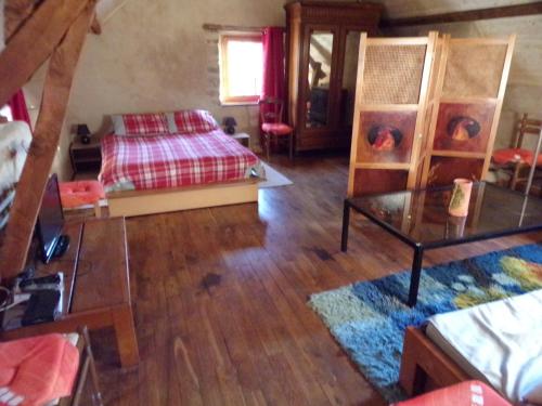una camera con letto e pavimento in legno di Petite Ferme d'Autrefois a Saint-Georges-Nigremont