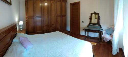 a bedroom with a white bed and a wooden cabinet at Stella di mare in Cagliari