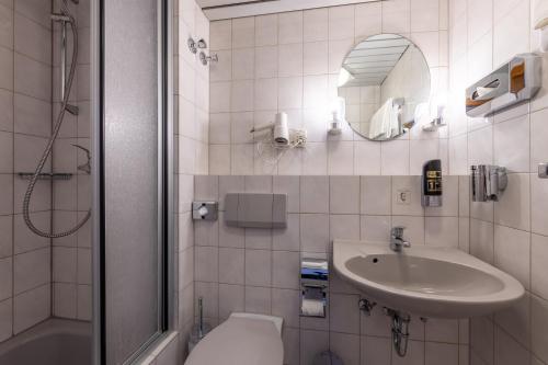 a bathroom with a sink and a toilet and a shower at Trip Inn Hotel Schumann in Düsseldorf
