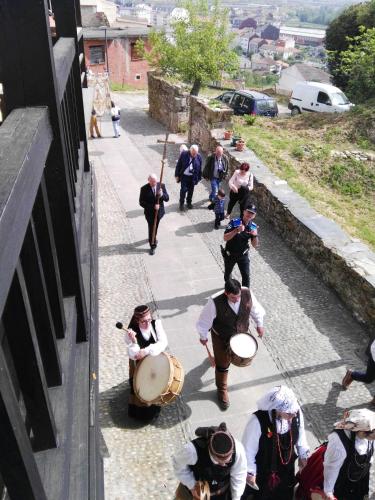a group of people walking down a street with drums at Falagueira in Monforte de Lemos