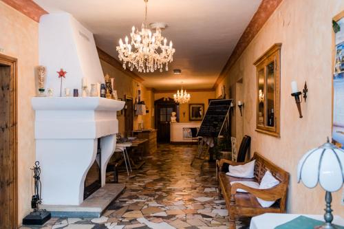 a living room with a fireplace and a chandelier at Posthotel Sachrang in Sachrang