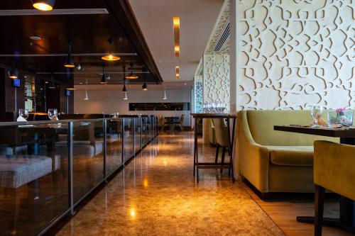 a restaurant with a couch and a bar at Copthorne Hotel Sharjah in Sharjah