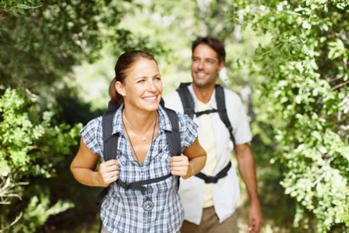 a man and a woman walking through a forest at Ruhehotel & Naturresort Rehbach - Adults only in Schattwald