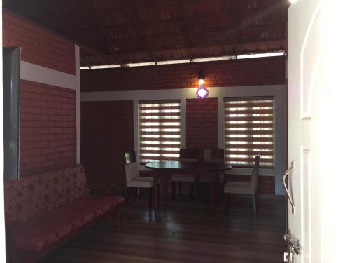 a dining room with a table and chairs in a room at Marsim Holiday Resort in Vythiri