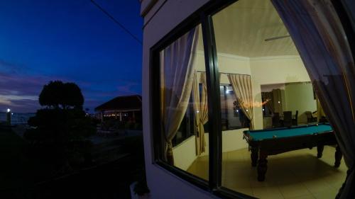 a window of a house with a pool table at Seaview Beach Resort in Jepara