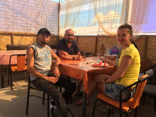 a group of people sitting at a table in a restaurant at AltynAi Guest House in Cholpon-Ata
