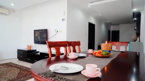 a dining room table with plates and a bowl of fruit at Seaview Beach Resort in Jepara