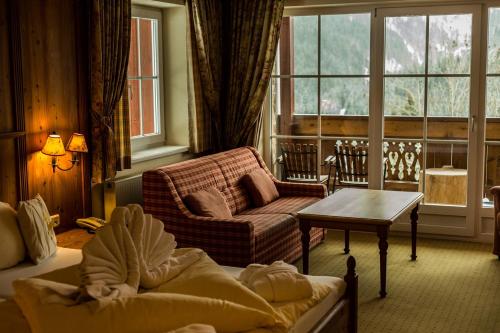 a living room with a couch and a table at Ruhehotel & Naturresort Rehbach - Adults only in Schattwald