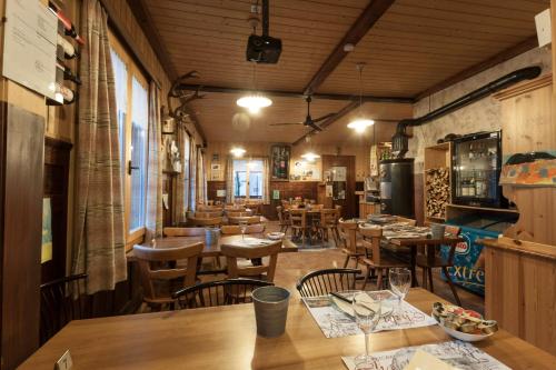 Ristorante Pensione Chalet Stazione في بوشيافو: غرفة طعام مع طاولات وكراسي خشبية