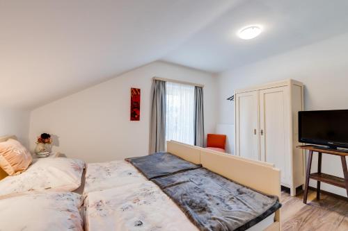 a bedroom with a bed and a flat screen tv at Gerli Appartement Mariazell in Mariazell