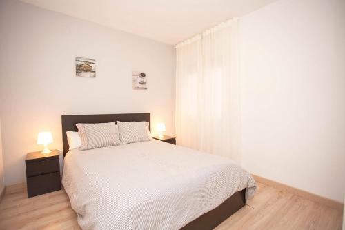 1 dormitorio blanco con 1 cama y 2 lámparas en Sitges Center & Beach with Sea View, en Sitges