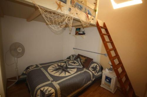 une chambre avec un lit superposé et une échelle dans l'établissement Maison de plage, à Frontignan