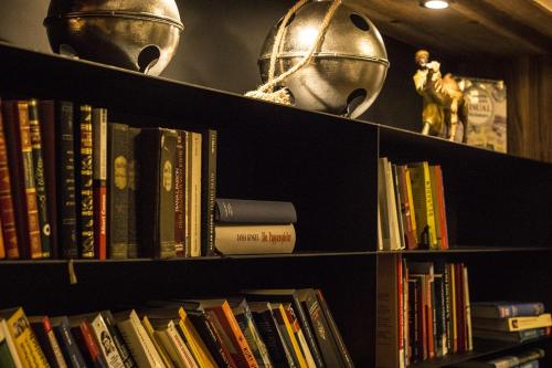 a book shelf filled with books and a helmet at Ruhehotel & Naturresort Rehbach - Adults only in Schattwald