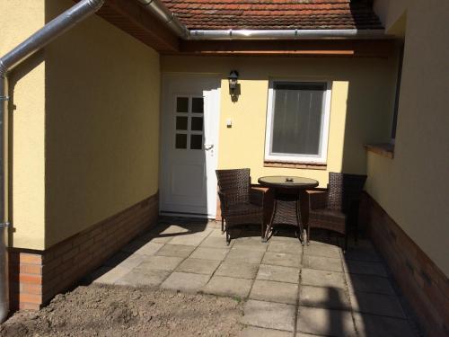 a patio with a table and chairs and a door at Liliom Vendégház in Visegrád