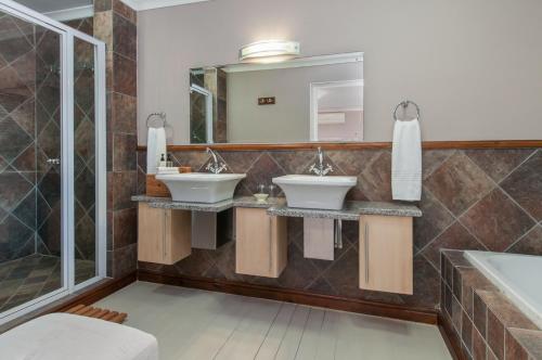 a bathroom with two sinks and a large mirror at Whale Away Guest House in Hermanus