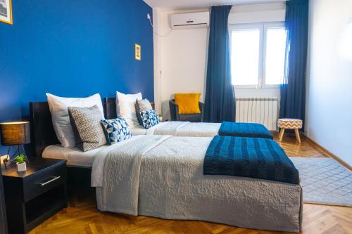 貝爾格勒的住宿－Apartment Wake Up For 4，一间卧室设有两张床和蓝色的墙壁