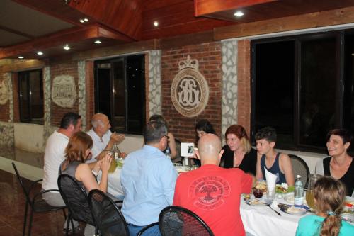 a group of people sitting around a table in a restaurant at Chateau Chikovani in Gordi