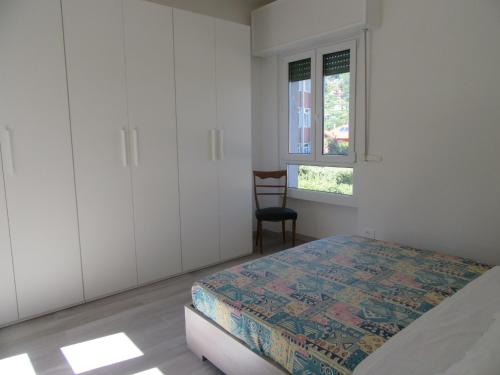 a bedroom with a bed and a chair in it at Casa Azalea in Verbania