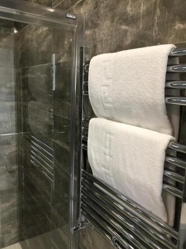a bunch of towels on a rack in a bathroom at Hotel La Cruz in Muxia