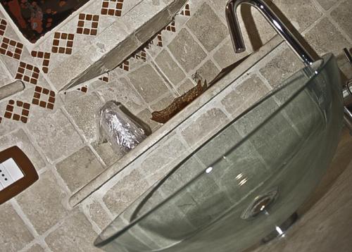 a glass sink in a bathroom with a mirror at Il Chiassetto Bolgheri in Bolgheri