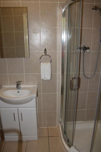 a bathroom with a sink and a shower at The Abbey House Hotel in Reading