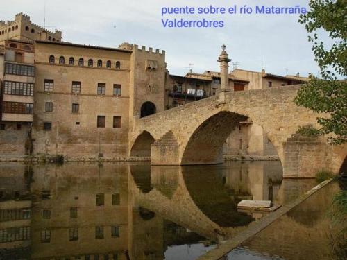 an old stone bridge over a river in a city at Casa rural Rosa in La Fresneda