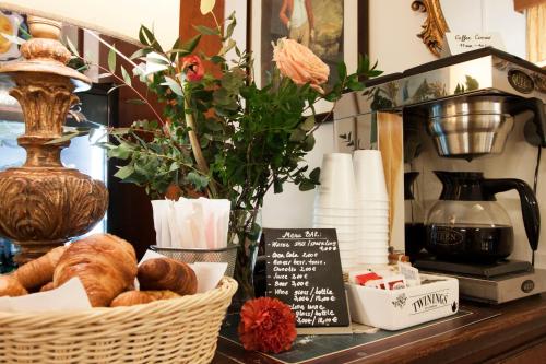 a basket of bread and a vase with flowers on a counter at Hotel Rex in Florence