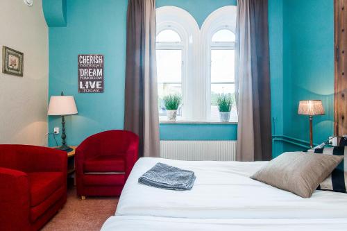a bedroom with a bed and a chair and a window at Centralstationens Vandrarhem in Norrköping