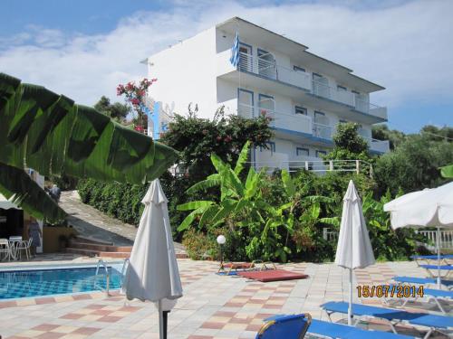 een hotel met een zwembad en stoelen en parasols bij YANNA Studios & Apartments in Tsilivi