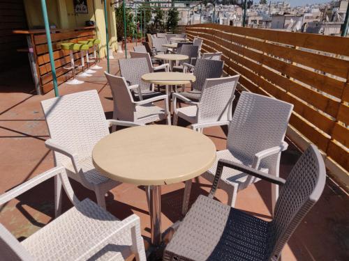 a patio area with chairs, tables and umbrellas at Hotel Exarchion in Athens