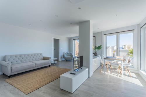 sala de estar con sofá y mesa en Indigo Rooftop, en A Coruña
