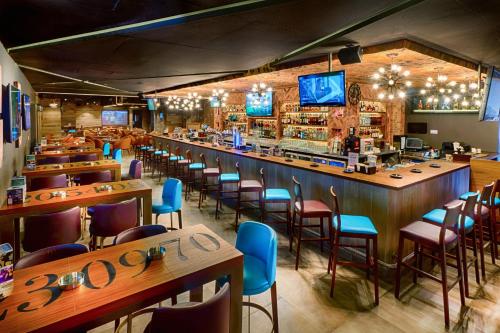 a restaurant with a bar with wooden tables and chairs at Citymax Hotel Bur Dubai in Dubai