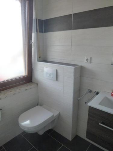 a bathroom with a white toilet and a sink at Ferienwohnung Berges in Edersee
