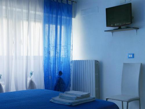 una camera blu con un letto e una televisione di pienosole B&B a Francavilla al Mare