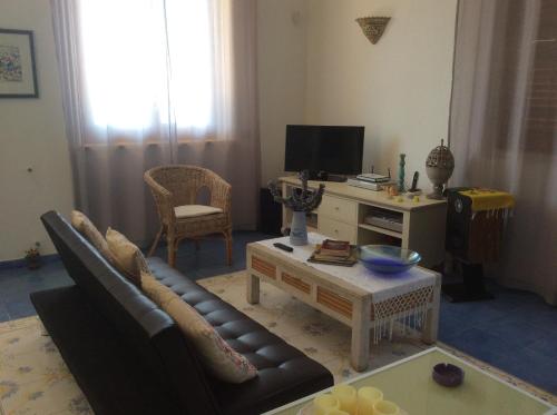 a living room with a couch and a table at Villa “La Giummarra” - Scivolo di Cornino in Custonaci