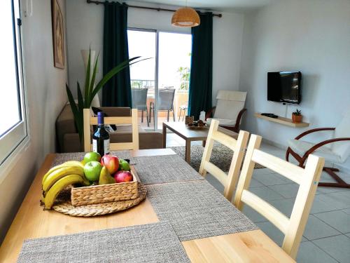 a dining room table with a basket of fruit on it at Top Seaview Apartment in Peyia in Peyia
