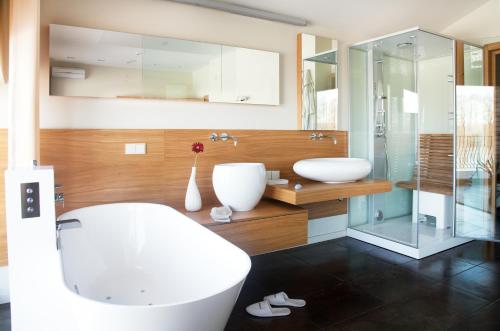 a bathroom with two sinks and a glass shower at Ami Residence in Druskininkai