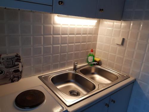 um lavatório de cozinha com uma luz em cima em COZZY STUDIO IN NEA MAKRI em Nea Makri