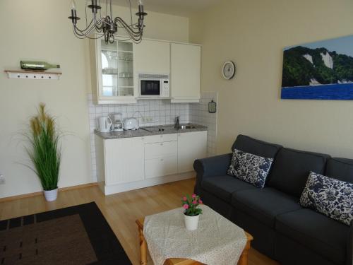 a living room with a couch and a kitchen at Fürstenhof Fewo Beagle in Sassnitz