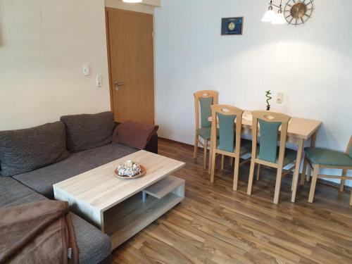 ein Wohnzimmer mit einem Sofa, einem Tisch und Stühlen in der Unterkunft Ferienwohnung Wendehake in Quedlinburg