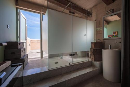 a bathroom with a glass shower and a toilet at Talbot & Bons Bed & Breakfast in Gudja